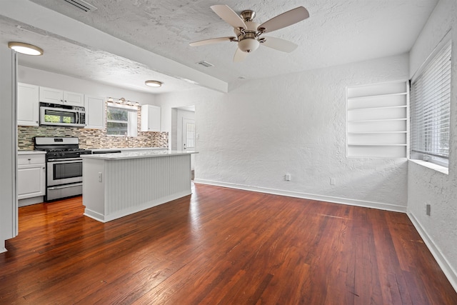 1316 NE 9th St, Gainesville, FL 32605 - kitchen with appliances with stainless steel finishes, a textured wall, tasteful backsplash, white cabinets, and dark wood-style flooring