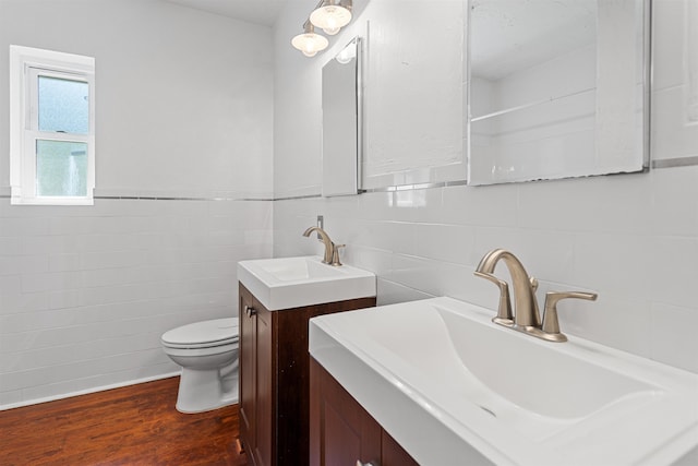 1316 NE 9th St, Gainesville, FL 32605 - bathroom featuring tile walls, vanity, wood finished floors, and wainscoting