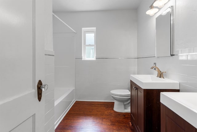 1316 NE 9th St, Gainesville, FL 32605 - bathroom featuring vanity, wood finished floors, shower / bathtub combination, and tile walls