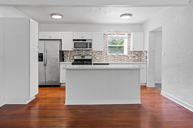 1316 NE 9th St, Gainesville, FL 32605 - kitchen with stainless steel appliances, a textured wall, light countertops, decorative backsplash, and dark wood finished floors