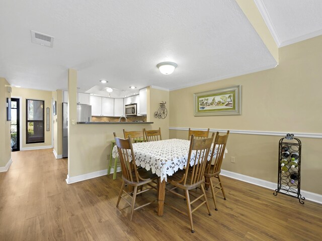 890 A1A Beach Blvd Unit 3, Saint Augustine, FL 32080 - dining area with baseboards, wood finished floors, crown molding, and recessed lighting