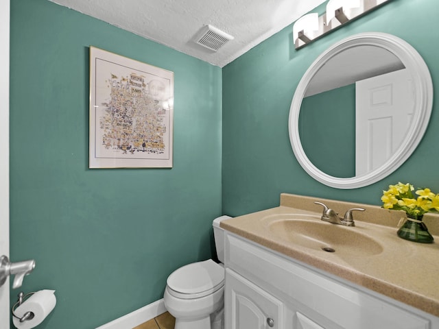 890 A1A Beach Blvd Unit 3, Saint Augustine, FL 32080 - half bath featuring vanity, toilet, a textured ceiling, tile patterned floors, and baseboards