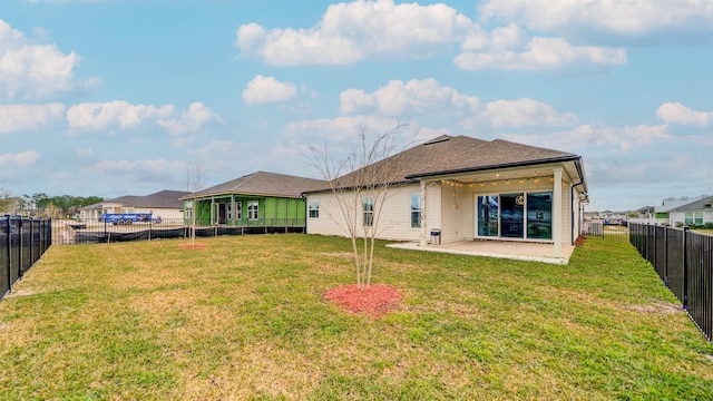 rear view of house featuring a lawn and a patio