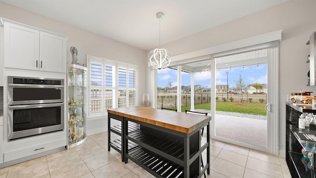 dining space with light tile patterned floors and a notable chandelier