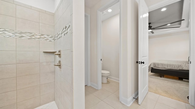 bathroom featuring toilet, a tile shower, tile patterned floors, and ceiling fan