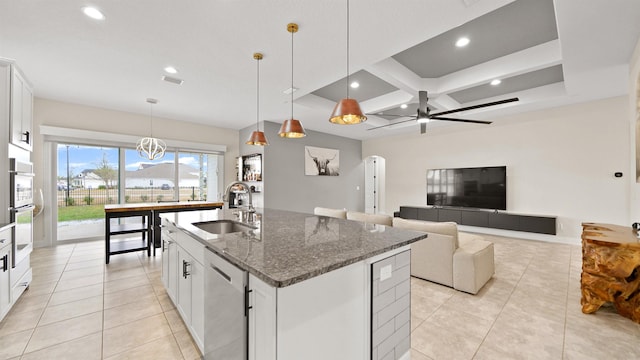 kitchen featuring white cabinets, sink, dishwasher, and an island with sink