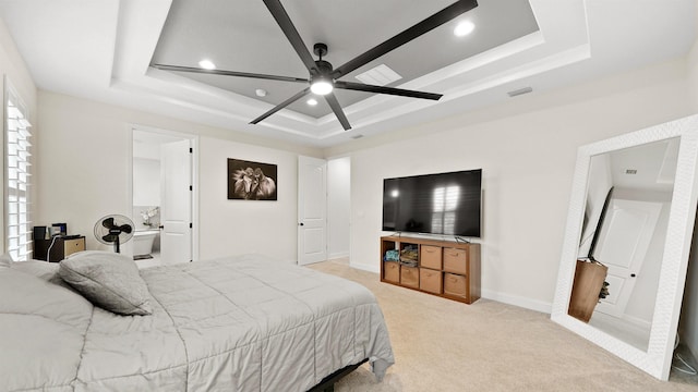 carpeted bedroom with ceiling fan, connected bathroom, and a tray ceiling