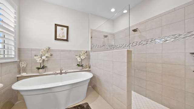 bathroom featuring tile patterned flooring, separate shower and tub, and tile walls