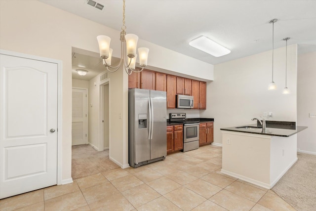 kitchen with a notable chandelier, appliances with stainless steel finishes, hanging light fixtures, and sink