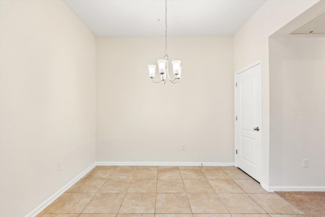 unfurnished room with a notable chandelier and light tile patterned flooring