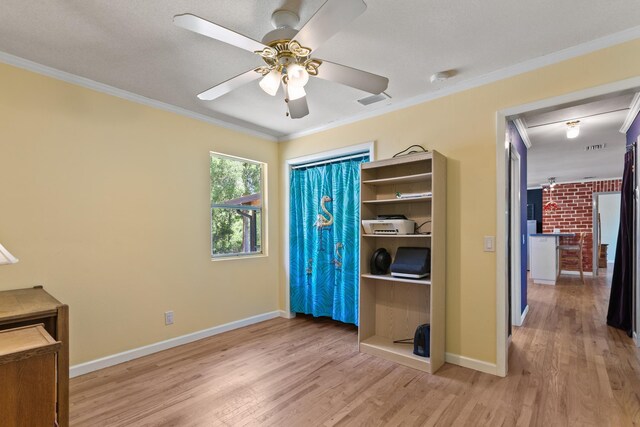 unfurnished bedroom with visible vents, crown molding, baseboards, light wood-style flooring, and ceiling fan