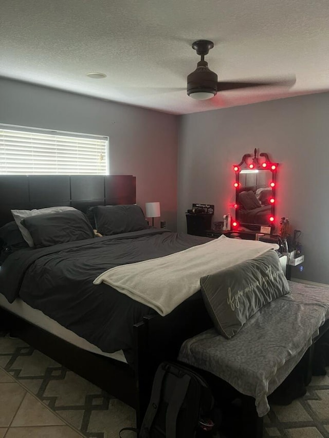 tiled bedroom with a textured ceiling and ceiling fan