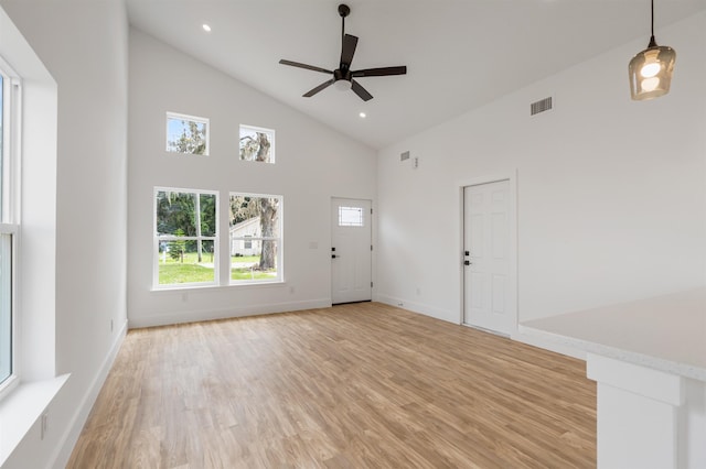 unfurnished living room featuring light hardwood / wood-style flooring, high vaulted ceiling, and ceiling fan