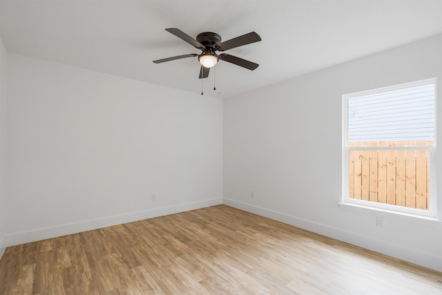 empty room with ceiling fan and light hardwood / wood-style flooring