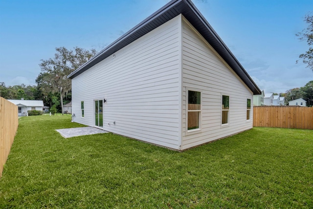 rear view of house featuring a lawn and a patio area