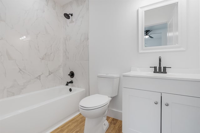 full bathroom featuring vanity, tiled shower / bath combo, ceiling fan, wood-type flooring, and toilet