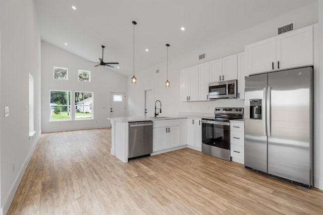 kitchen featuring kitchen peninsula, appliances with stainless steel finishes, ceiling fan, decorative light fixtures, and white cabinets