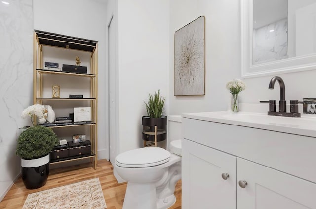 bathroom featuring vanity, wood-type flooring, and toilet