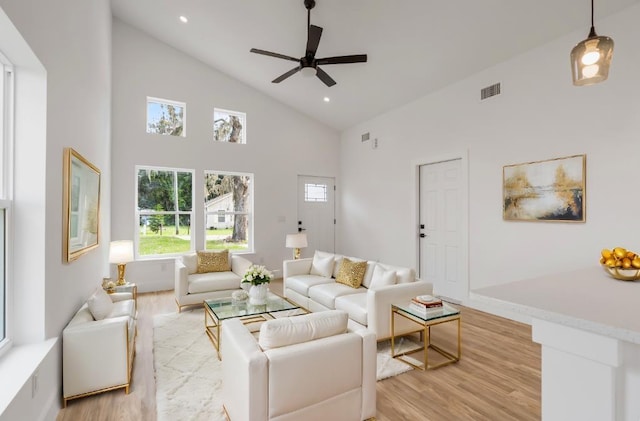 living room featuring light hardwood / wood-style floors, high vaulted ceiling, and ceiling fan