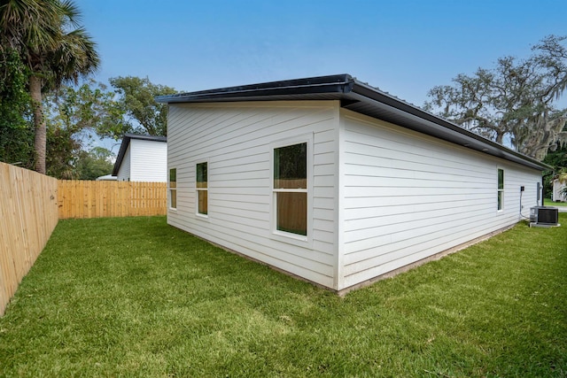 view of side of property featuring a yard and central AC unit