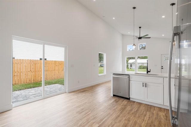 kitchen featuring white cabinets, high vaulted ceiling, decorative light fixtures, and appliances with stainless steel finishes