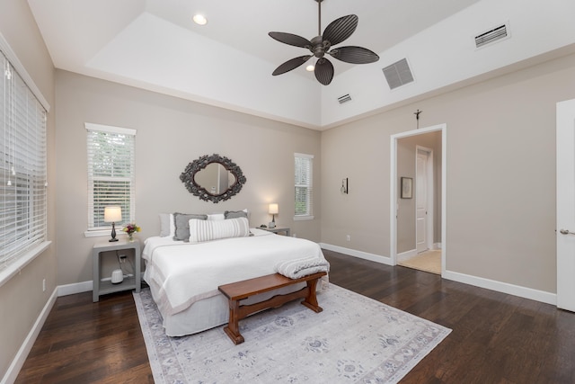 bedroom with ceiling fan, ensuite bathroom, and dark wood-type flooring