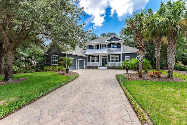 view of front of house featuring a porch, a garage, and a front yard