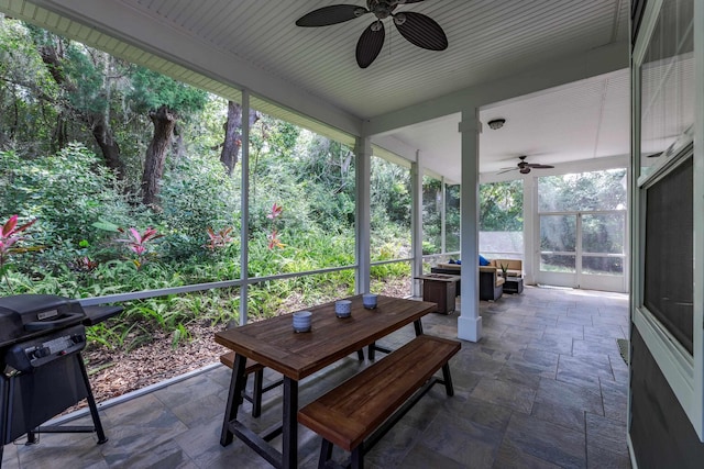 sunroom featuring ceiling fan and plenty of natural light