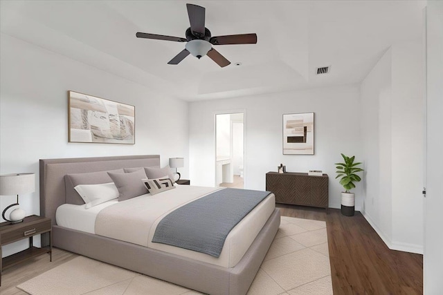 980 Windward Way, Saint Augustine, FL 32080 - bedroom featuring a raised ceiling, wood finished floors, baseboards, ceiling fan, and connected bathroom