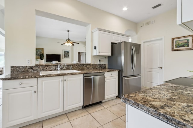 kitchen with light tile patterned flooring, a sink, a ceiling fan, white cabinets, and appliances with stainless steel finishes