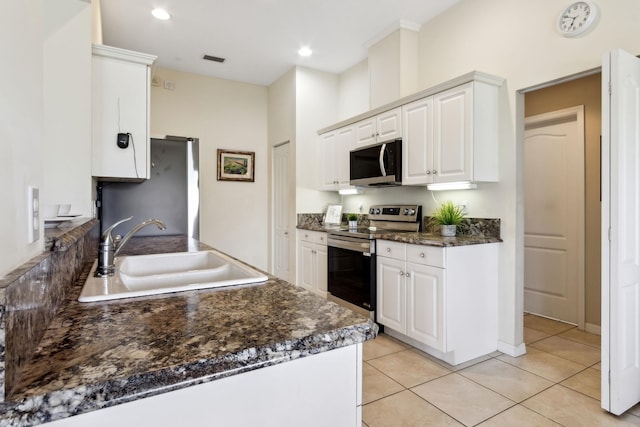 kitchen with stainless steel appliances, white cabinets, a sink, and visible vents