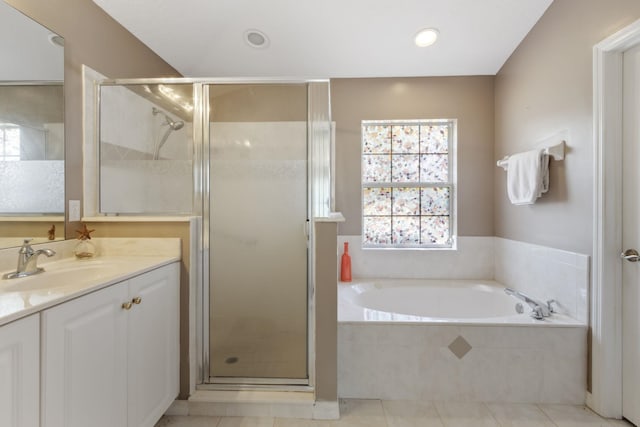 full bath featuring a stall shower, tile patterned flooring, a garden tub, and vanity