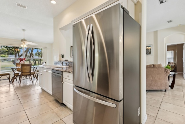 kitchen with stainless steel appliances, light tile patterned flooring, visible vents, and white cabinetry