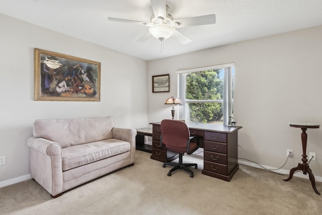 office area with light carpet, a textured ceiling, a ceiling fan, and baseboards