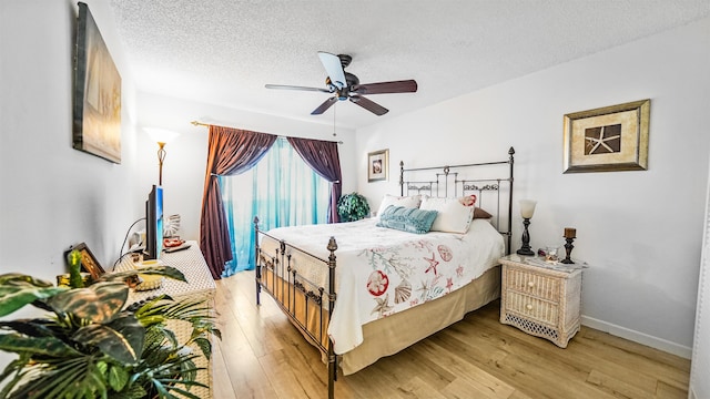 bedroom featuring a textured ceiling, ceiling fan, and light hardwood / wood-style flooring