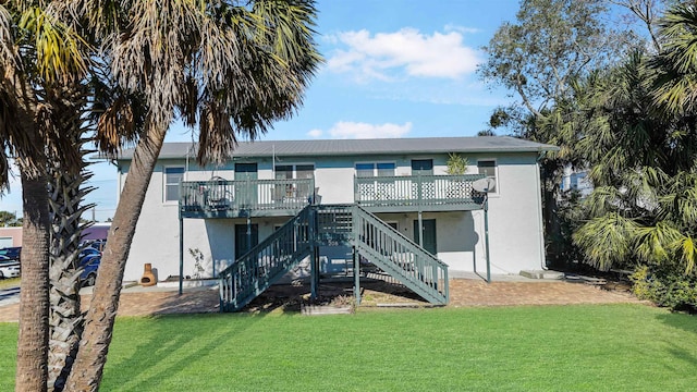 back of property with a wooden deck and a yard