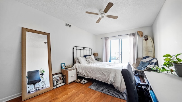 bedroom featuring ceiling fan, a textured ceiling, and hardwood / wood-style flooring