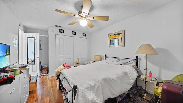 bedroom featuring ceiling fan, a closet, a textured ceiling, and wood-type flooring