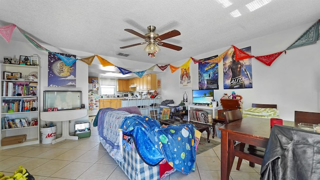 living room with a textured ceiling, ceiling fan, and light tile patterned flooring