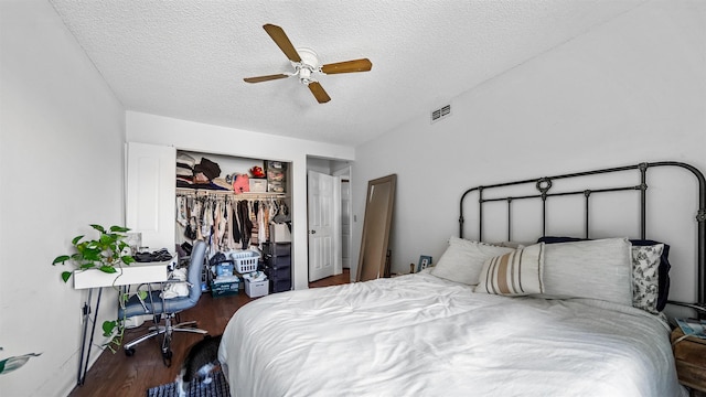 bedroom with ceiling fan, dark wood-type flooring, a textured ceiling, and a closet