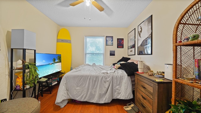 bedroom with ceiling fan, a textured ceiling, and wood-type flooring