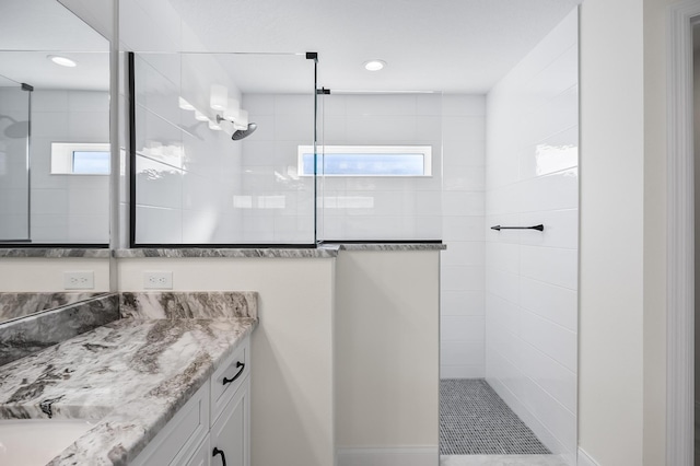 bathroom featuring vanity and tiled shower