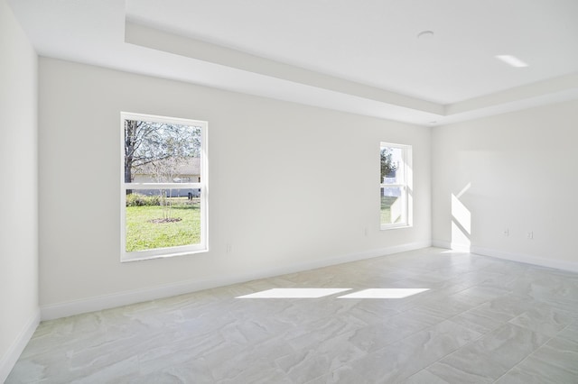 unfurnished room featuring a tray ceiling