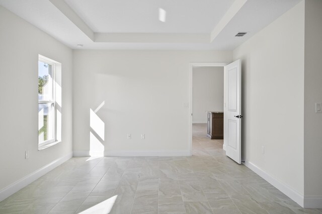 empty room featuring a raised ceiling