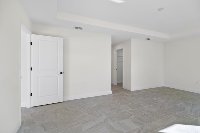 spare room with a tray ceiling