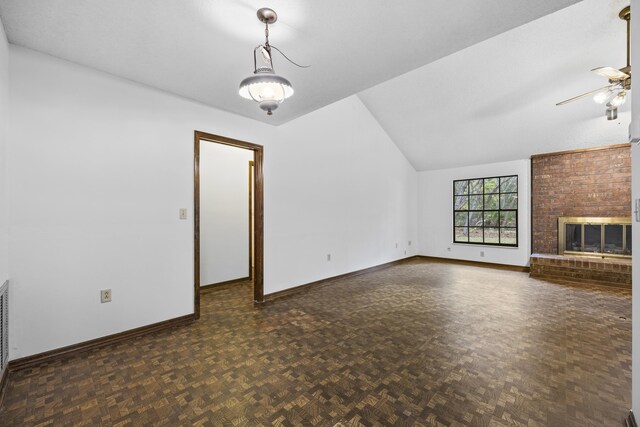 unfurnished living room with dark parquet flooring, ceiling fan, vaulted ceiling, and a brick fireplace