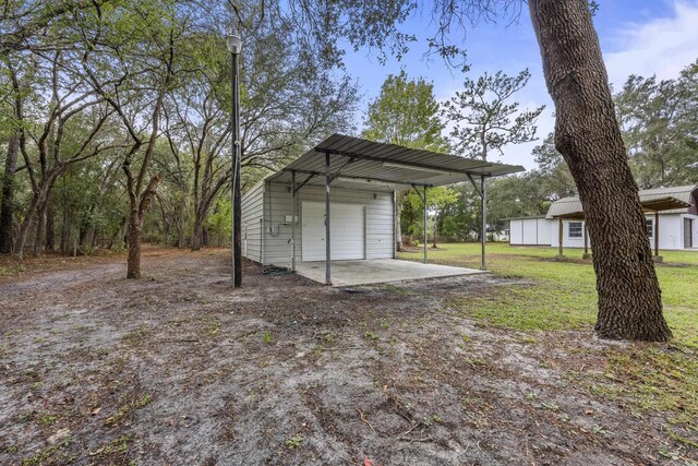 view of yard featuring an outdoor structure and a carport