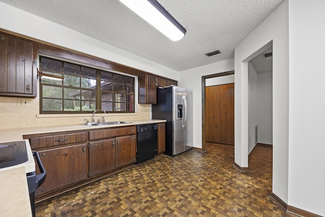 kitchen featuring dark parquet flooring, a textured ceiling, dark brown cabinetry, sink, and black appliances