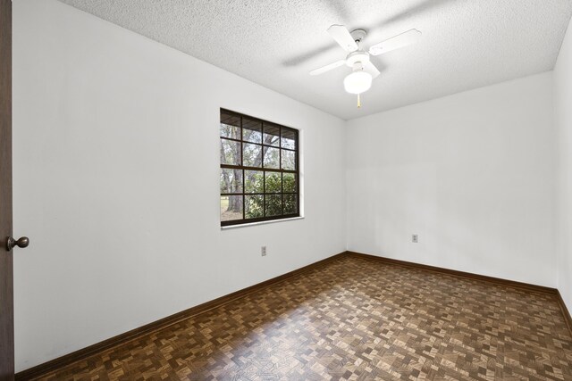 unfurnished room featuring a textured ceiling, ceiling fan, and dark parquet floors