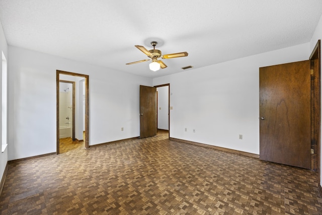 unfurnished bedroom featuring a textured ceiling, ceiling fan, ensuite bathroom, and dark parquet floors